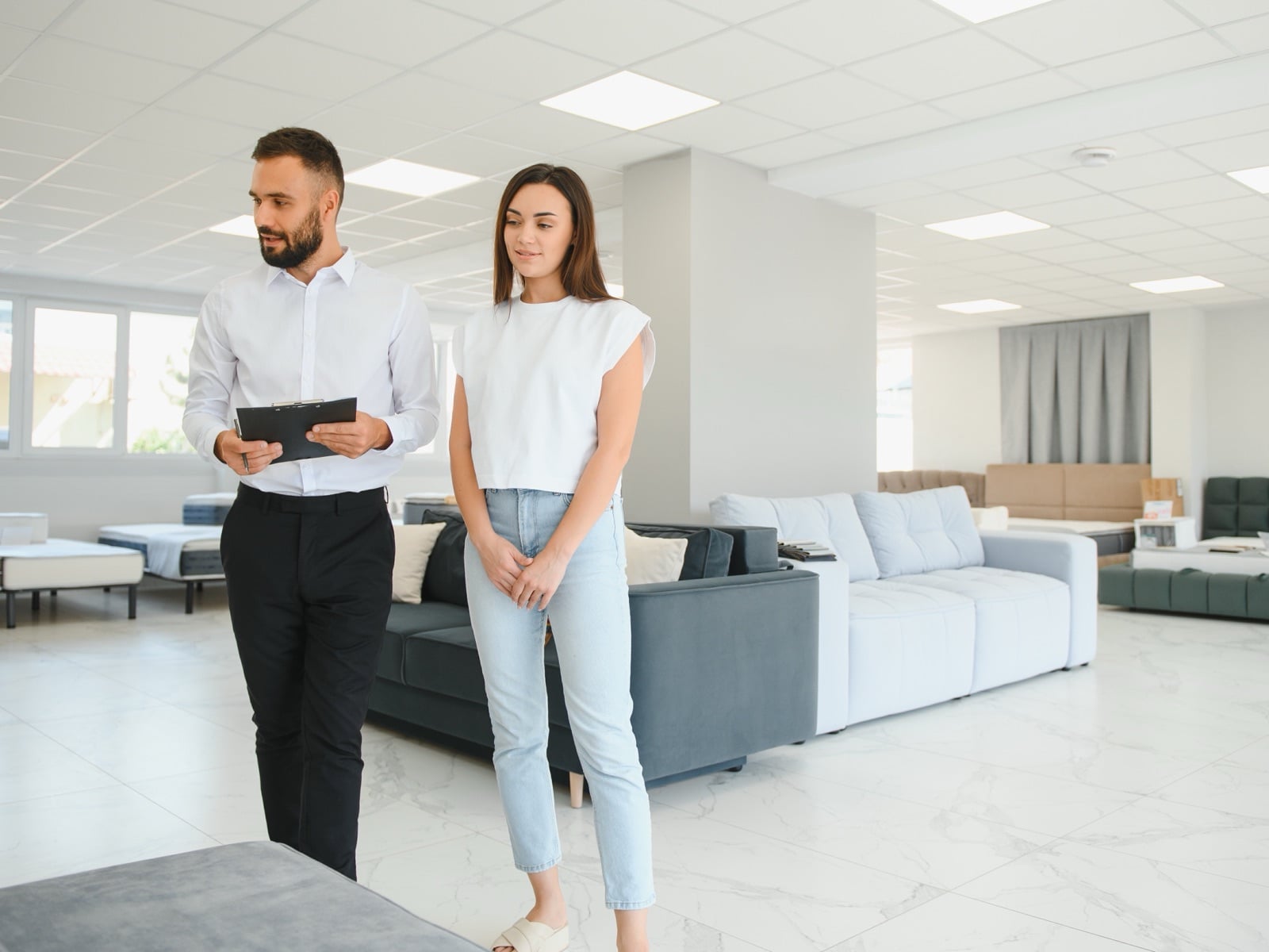 A furniture store associate walking a customer through the showroom